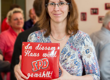 Unser Mitglied Nina Gerling hält ein Schild mit der Beschriftung In diesem Haus wird SPD gewählt.